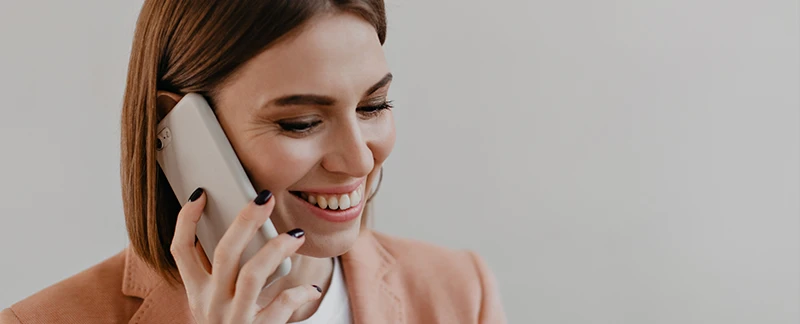 Donna che tiene in Mano un telefono: contatta il servizio clienti di ParkinGO per dubbi o problemi